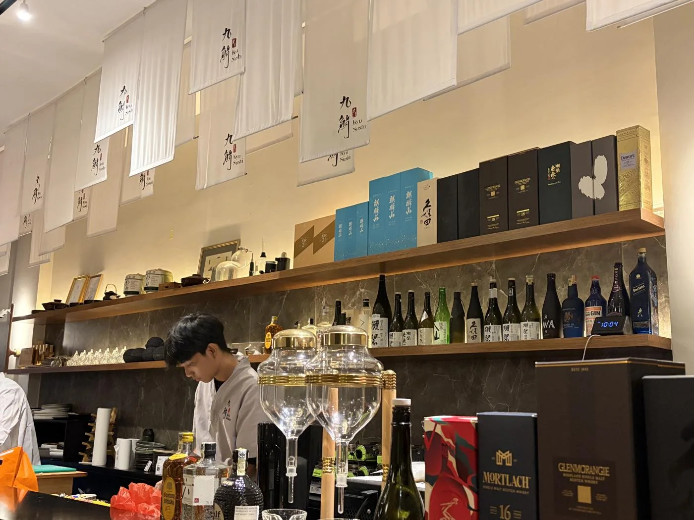 Kyu Izakayaの店内。カウンターと酒瓶が並ぶ、食事をした店の雰囲気