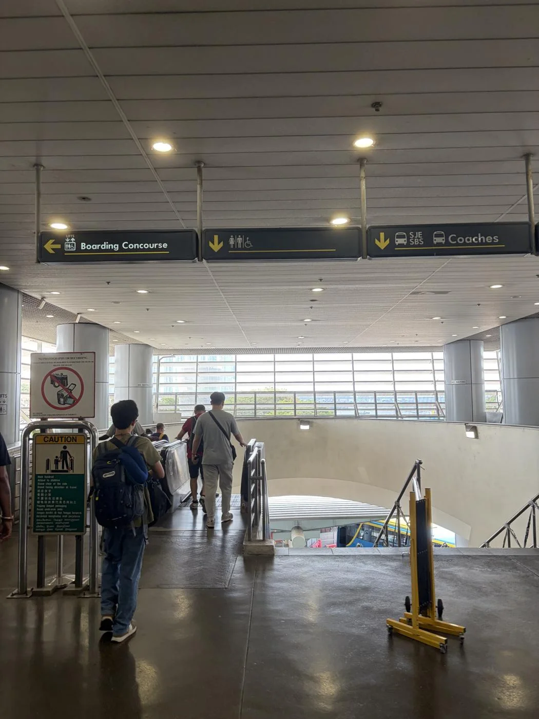 出国後に撮ったBoarding Concourse・Coachesの案内。バス乗り場へ下りる階段とエスカレーター