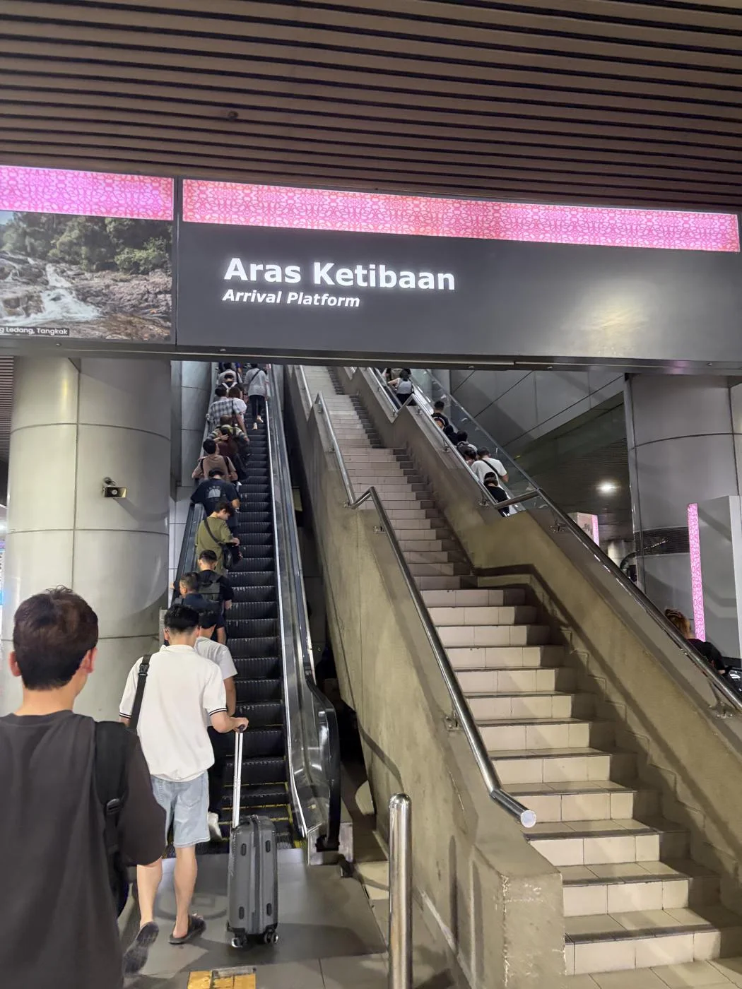マレーシア側に着いて撮ったArrival Platformの表示とエスカレーター。バスを降りた後の場面